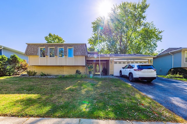 tri-level home featuring a garage and a front lawn