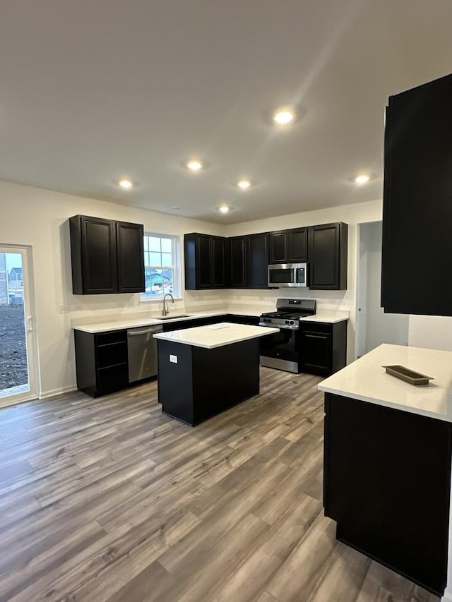 kitchen with sink, a center island, stainless steel appliances, and light hardwood / wood-style flooring