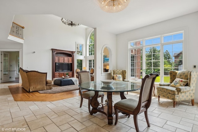 dining area with stone tile floors and a towering ceiling