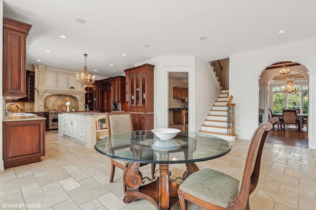 dining area featuring recessed lighting, stairway, an inviting chandelier, and stone tile floors