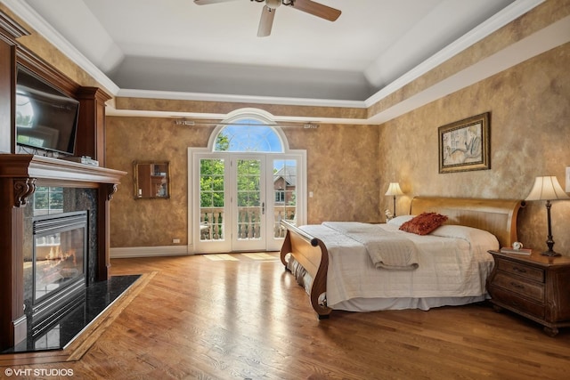 bedroom featuring wood finished floors, visible vents, a fireplace, ceiling fan, and access to exterior