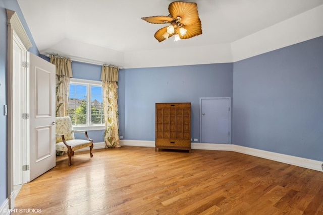 unfurnished room with a ceiling fan, light wood-type flooring, and baseboards