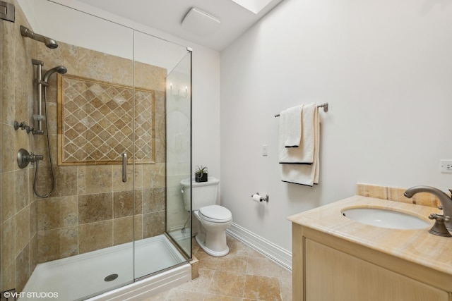 bathroom with vanity, toilet, baseboards, and a stall shower