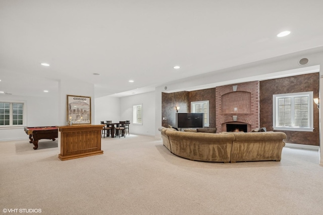 living area with recessed lighting, light colored carpet, and a fireplace