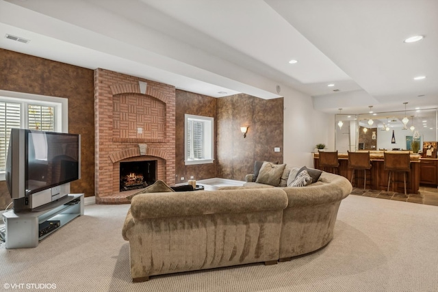 living area with visible vents, recessed lighting, a fireplace, and carpet