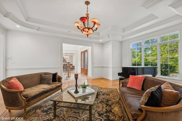 living room featuring a tray ceiling, a notable chandelier, ornamental molding, and stairway