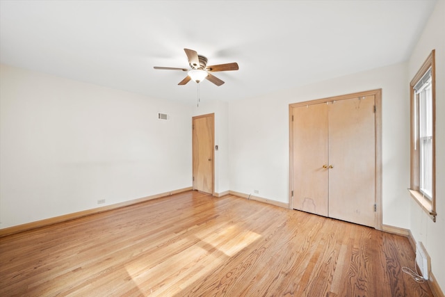 unfurnished bedroom with ceiling fan, a closet, and light wood-type flooring