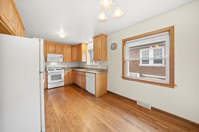 kitchen featuring white appliances, sink, light hardwood / wood-style flooring, light brown cabinetry, and a notable chandelier