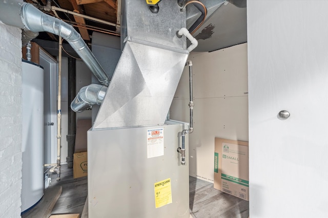 utility room featuring gas water heater and heating unit