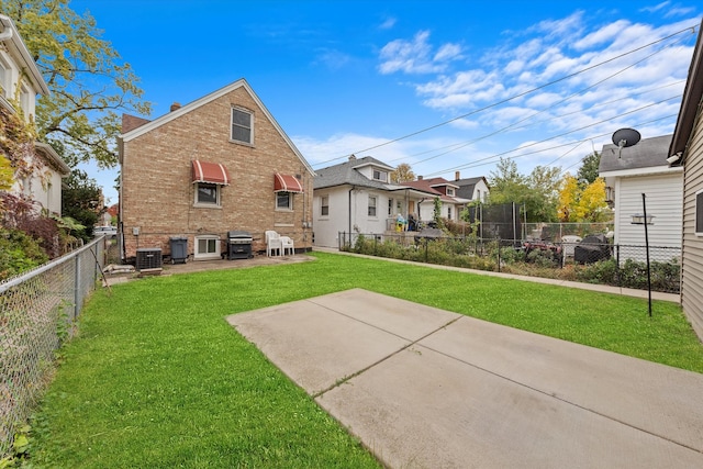 rear view of property featuring a lawn and a patio area