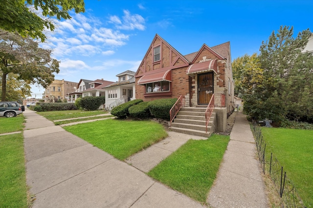 tudor-style house featuring a front yard