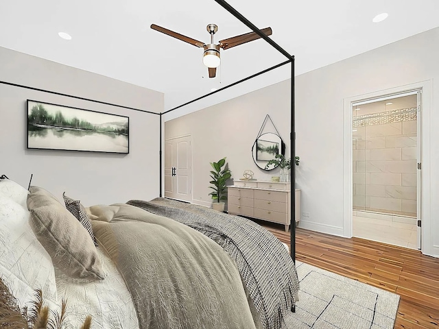 bedroom with ensuite bath, ceiling fan, and wood-type flooring