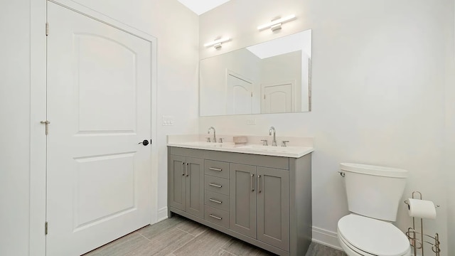 bathroom with hardwood / wood-style floors, vanity, and toilet