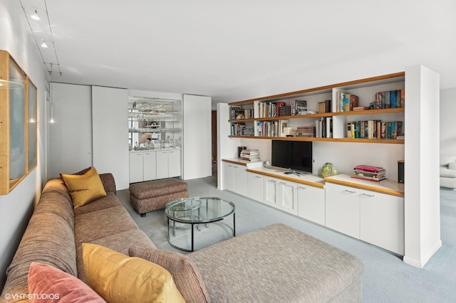 living room featuring light carpet and built in desk