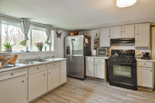 kitchen featuring stainless steel fridge with ice dispenser, gas stove, light hardwood / wood-style floors, and white cabinetry