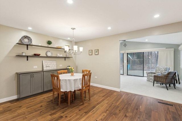 dining space featuring dark hardwood / wood-style flooring and a notable chandelier