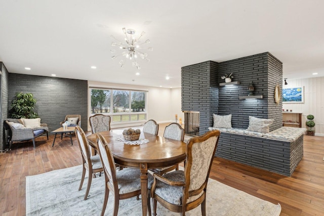 dining room featuring a fireplace, a chandelier, and light hardwood / wood-style floors