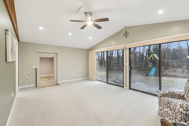 unfurnished living room featuring vaulted ceiling, light colored carpet, and ceiling fan