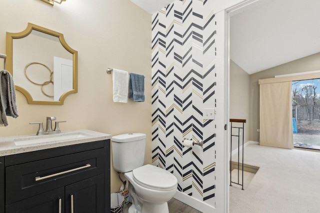 bathroom featuring vanity, vaulted ceiling, and toilet