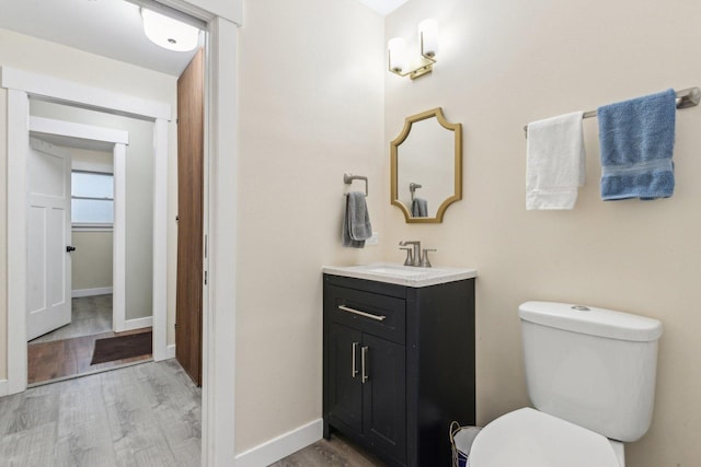 bathroom with wood-type flooring, toilet, and vanity