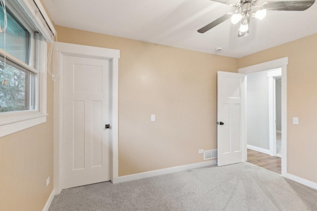 unfurnished bedroom featuring ceiling fan and light colored carpet