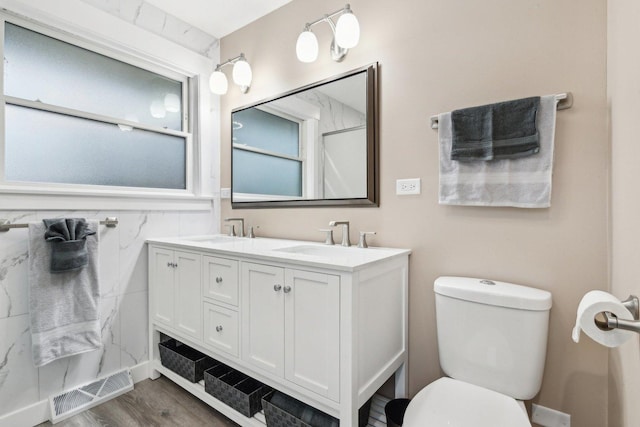 bathroom with vanity, toilet, hardwood / wood-style floors, and tile walls