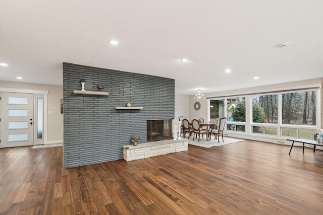 unfurnished living room with a multi sided fireplace and wood-type flooring