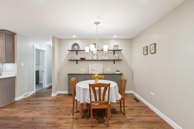 dining room with dark hardwood / wood-style floors and a chandelier