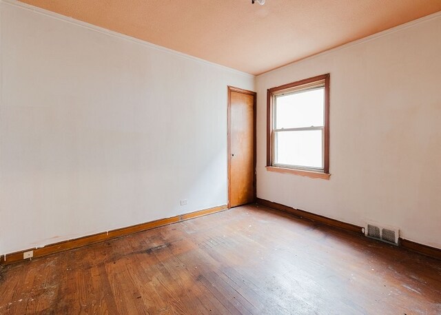 unfurnished room with crown molding and hardwood / wood-style floors