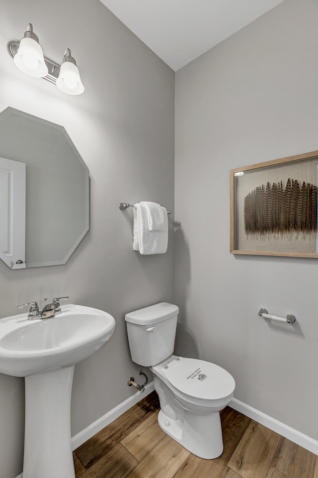 bathroom featuring sink, wood-type flooring, and toilet