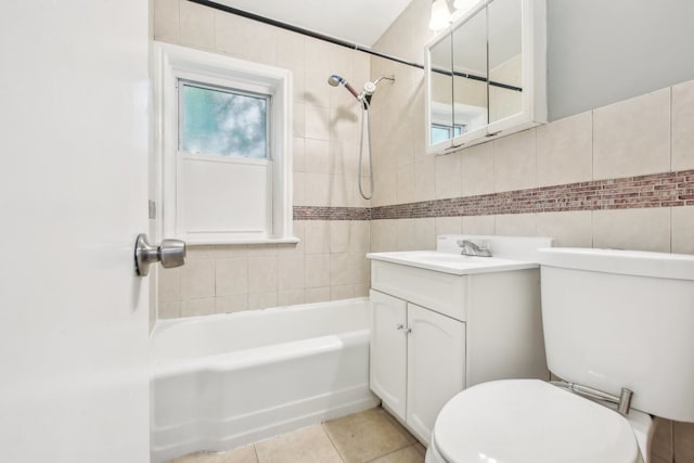 full bathroom featuring vanity, tile patterned floors, tiled shower / bath combo, toilet, and tile walls