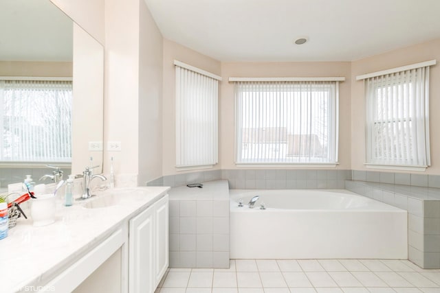 bathroom featuring tile patterned flooring, vanity, and a washtub