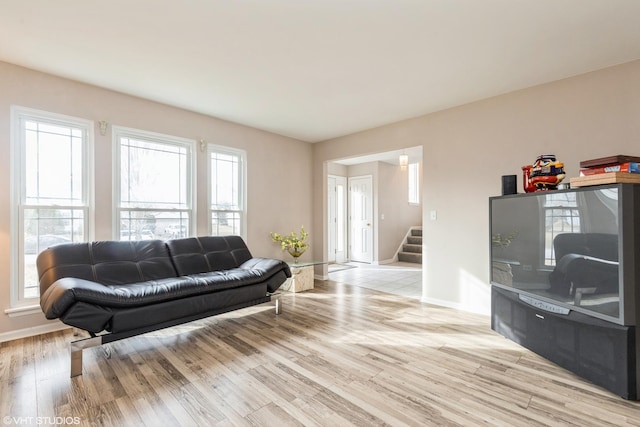 living room with light hardwood / wood-style floors and a healthy amount of sunlight