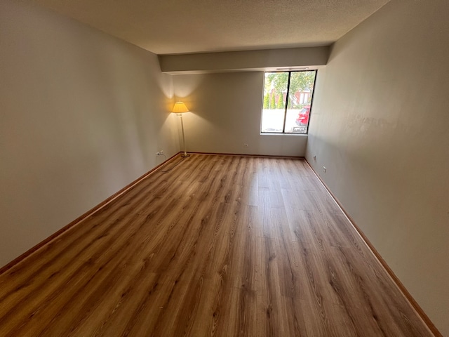 empty room featuring hardwood / wood-style floors and a textured ceiling