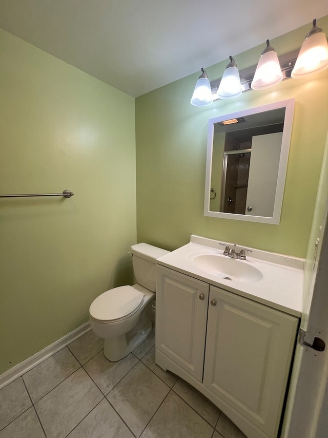 bathroom with tile patterned flooring, vanity, an enclosed shower, and toilet