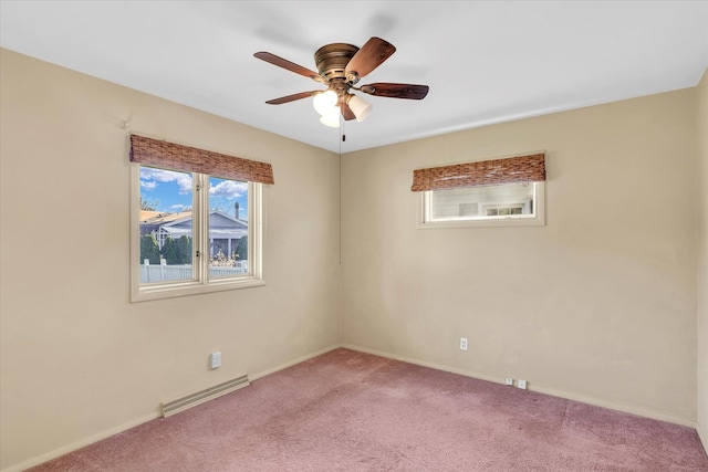 carpeted spare room featuring baseboard heating and ceiling fan