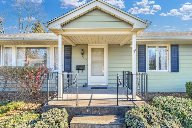 view of exterior entry featuring covered porch