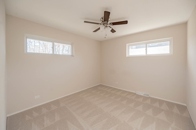 unfurnished room featuring light colored carpet and ceiling fan