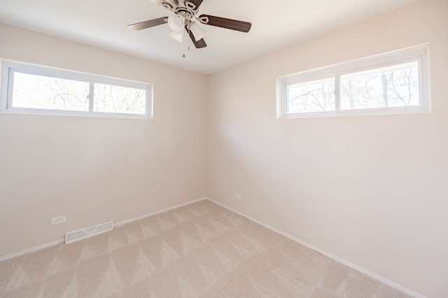 carpeted empty room featuring plenty of natural light and ceiling fan