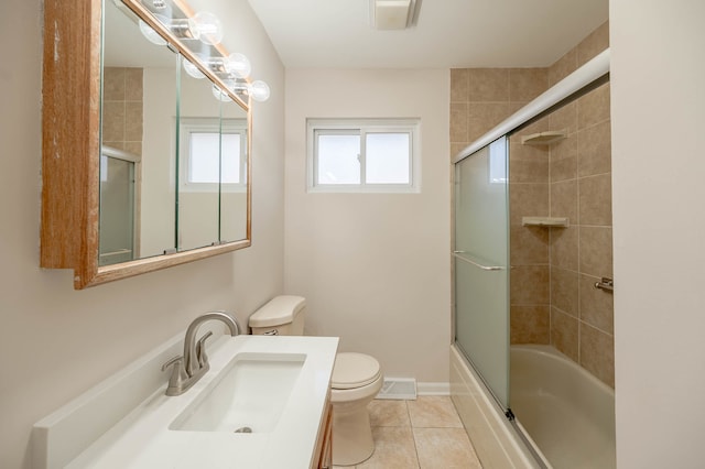 full bathroom with combined bath / shower with glass door, tile patterned floors, vanity, and toilet