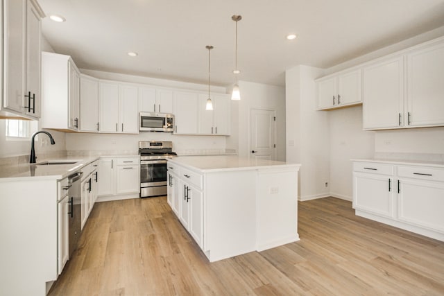 kitchen with white cabinets, sink, a center island, and appliances with stainless steel finishes