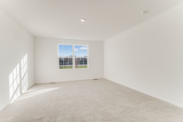 spare room featuring light carpet