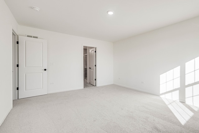 spare room featuring light colored carpet