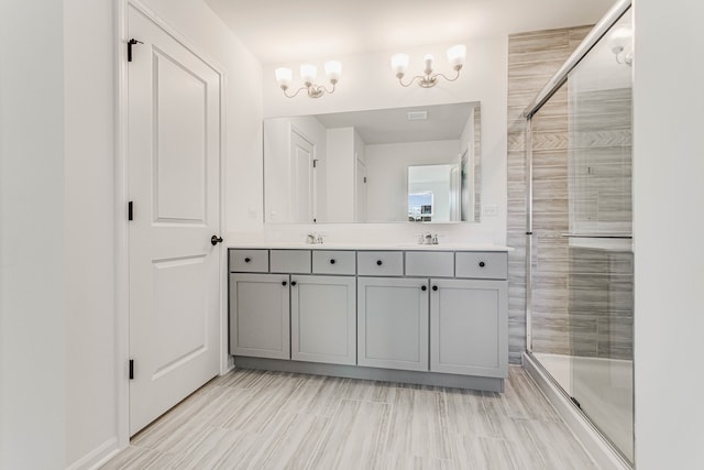 bathroom with vanity, a shower with door, and a notable chandelier