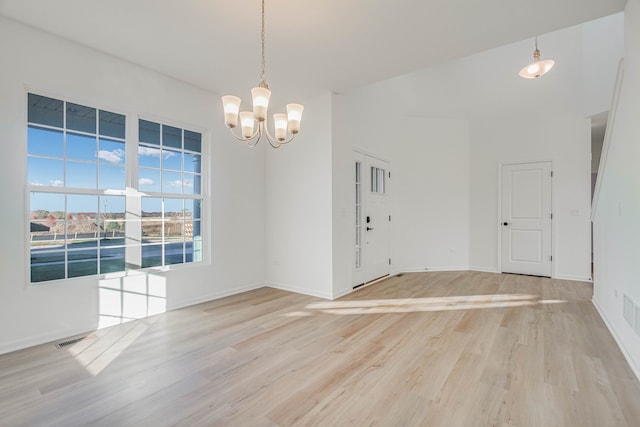 interior space with a notable chandelier and light hardwood / wood-style floors