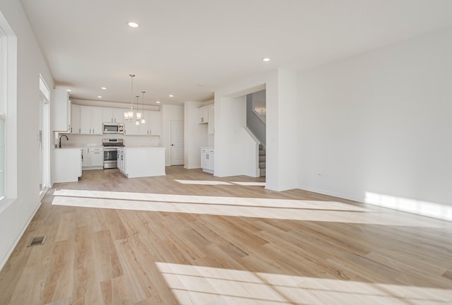 unfurnished living room featuring light hardwood / wood-style floors and sink