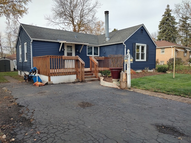 rear view of house with a lawn and a wooden deck