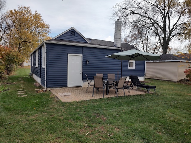 rear view of property featuring a yard and a patio