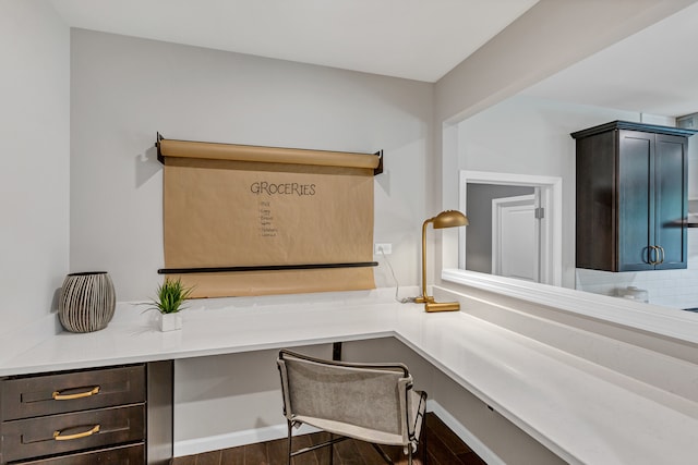 office featuring dark hardwood / wood-style flooring and built in desk