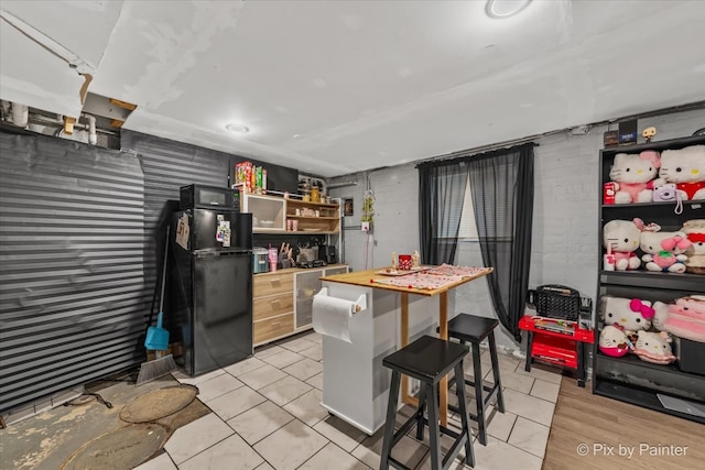 kitchen with a breakfast bar, a center island, butcher block countertops, and black appliances